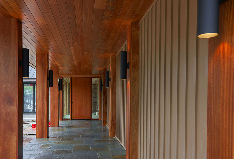 Custom Solid Wood Columns, Half Columns, Pivot Door and Soffit Cladding in Sapele Mahogany for Main Entrance.