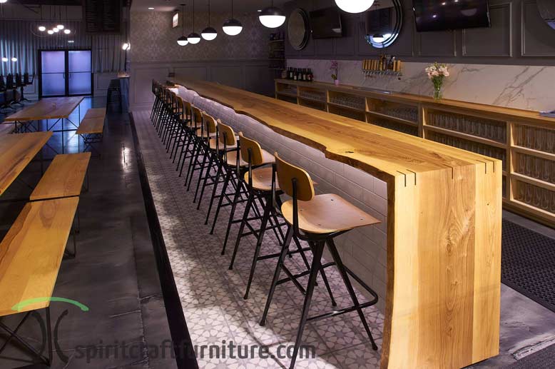 White Ash live edge bar top with waterfall and restaurant tables in Chicago area brewery and restaurant.