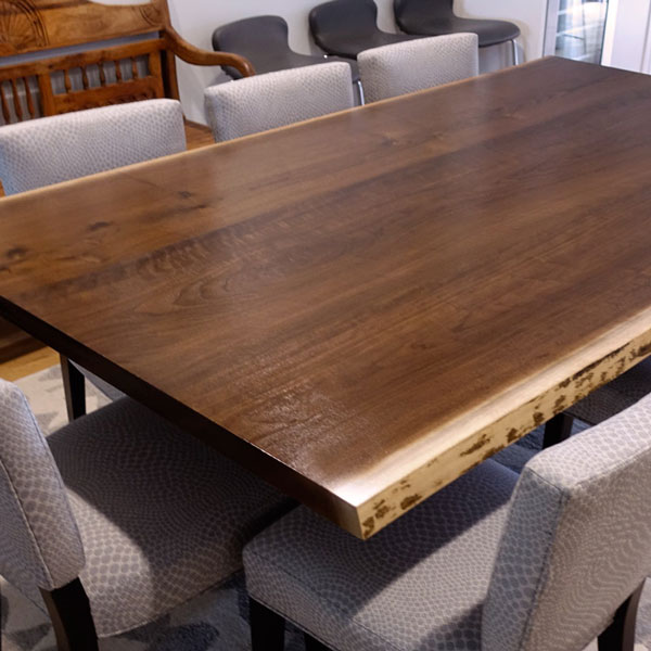 Natural-edge dining table from kiln dried Black Walnut slabs with spider base in Wilmette Illinois residence