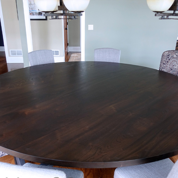 96 inch Diameter Round Stained Sapele Mahogany Table Top, Crafted in Two Sections with Custom Cross Trapezoid Base, Assembled On-Site by Spiritcraft Furniture in East Dundee, Illinois.