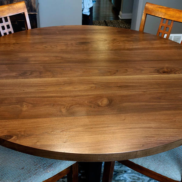 Custom Round, Wide Plank Black Walnut Sixty Inch Dining Table with Steel Crossed Trapezoid Base for Chicago Area Client