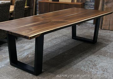 Live edge Walnut dining table in solid book matched slabs with black steel trapezoid legs in our Chicago area furniture store